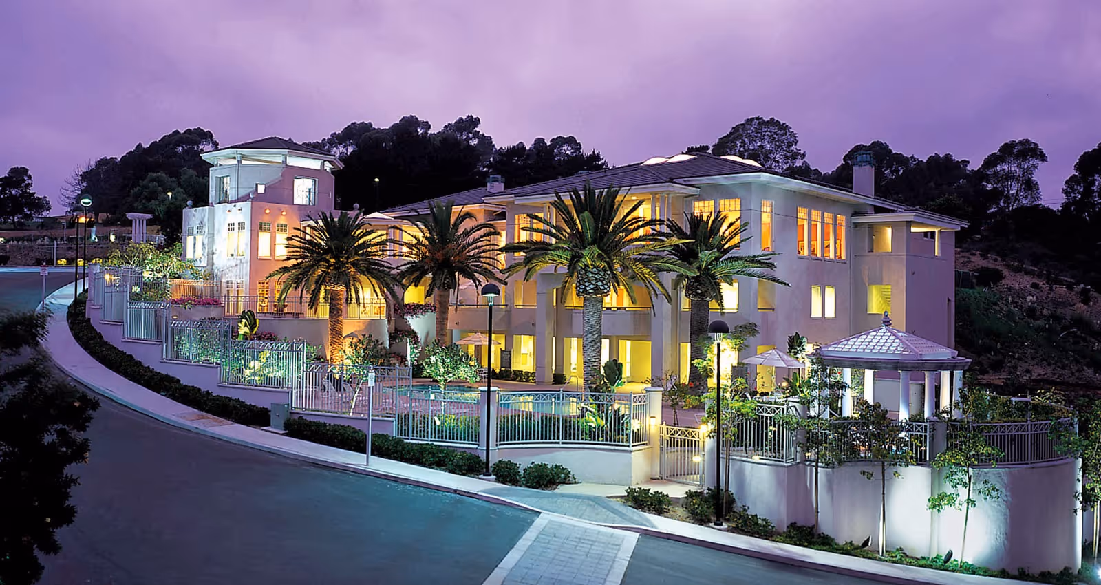 Evening exterior view of Sea Bluffs Ivy Signature Living with illuminated facade