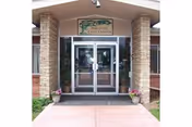 Entrance to Parkview Care Center with glass doors, stone pillars, and planters.