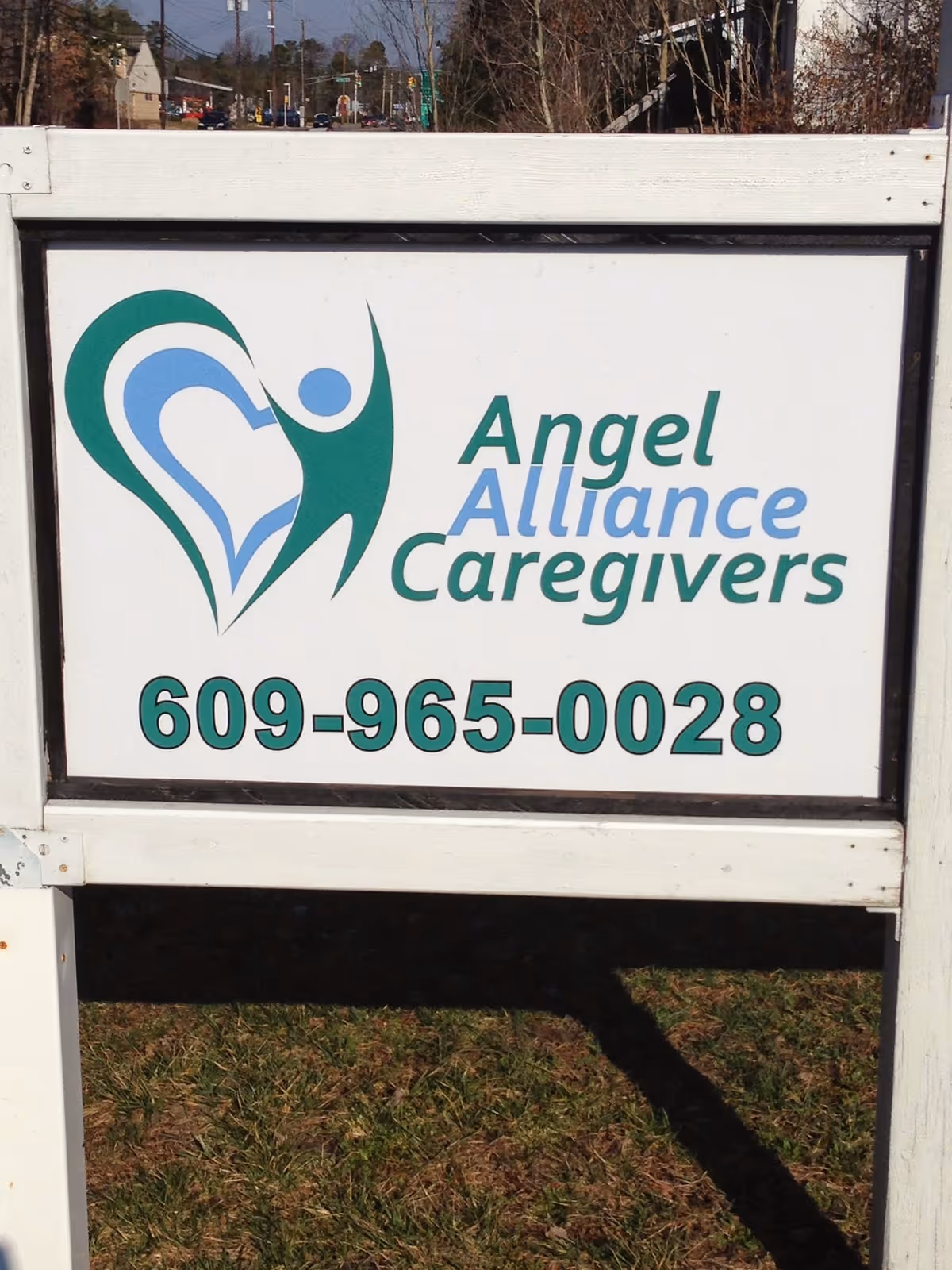 Outdoor signboard for Angel Alliance Caregivers with logo and phone number.