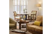 Cozy living room with round dining table, chairs, sofa, and lamp.