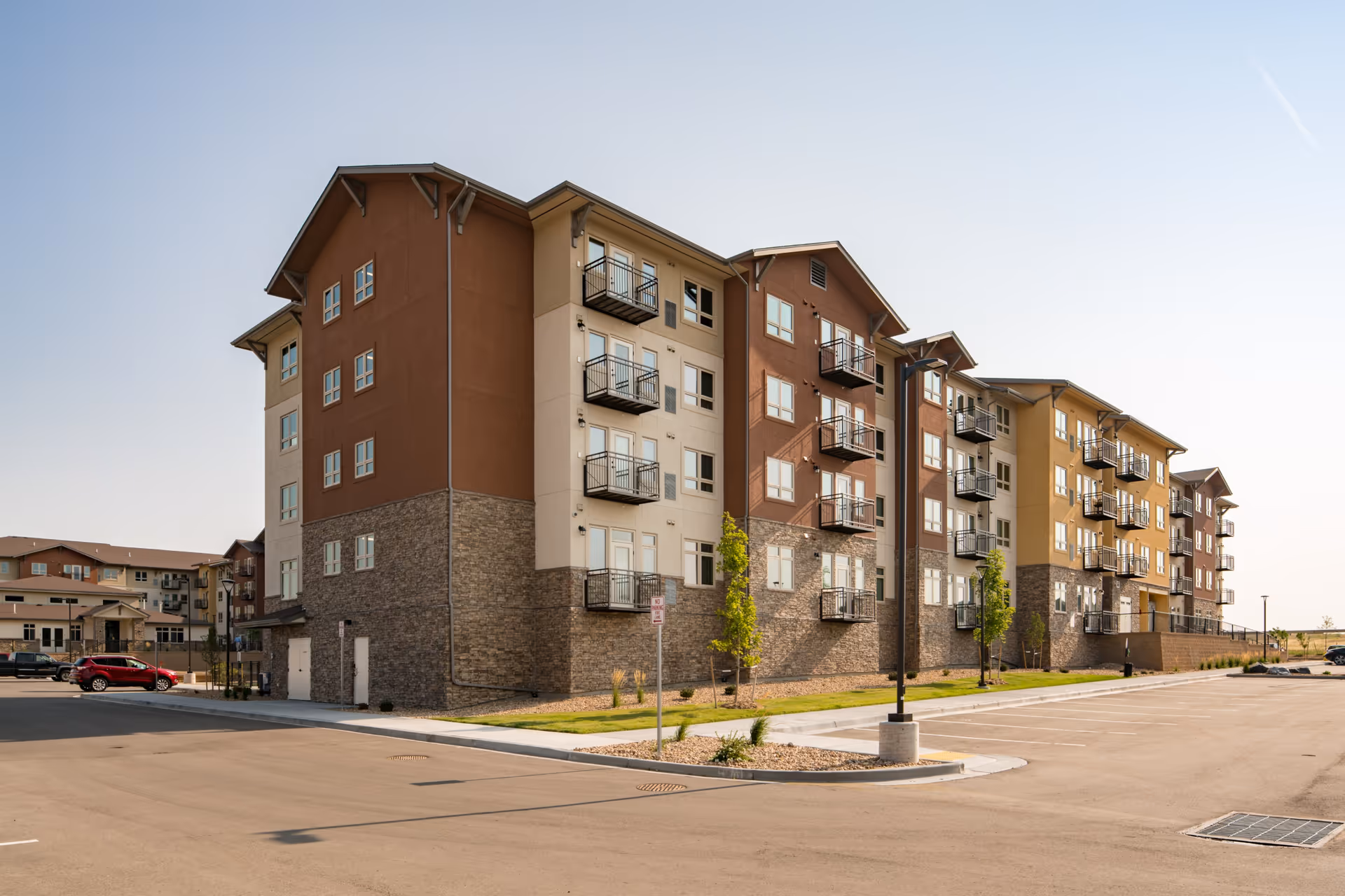 Exterior view of Affinity at Copperleaf senior living facility with balconies and parking.
