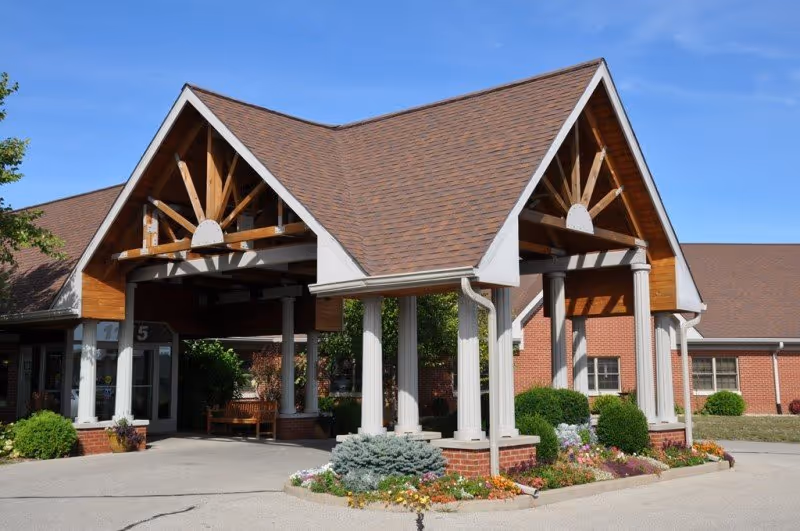 Snyder Village Assisted Living building with peaked wooden roof entrance and landscaped front.