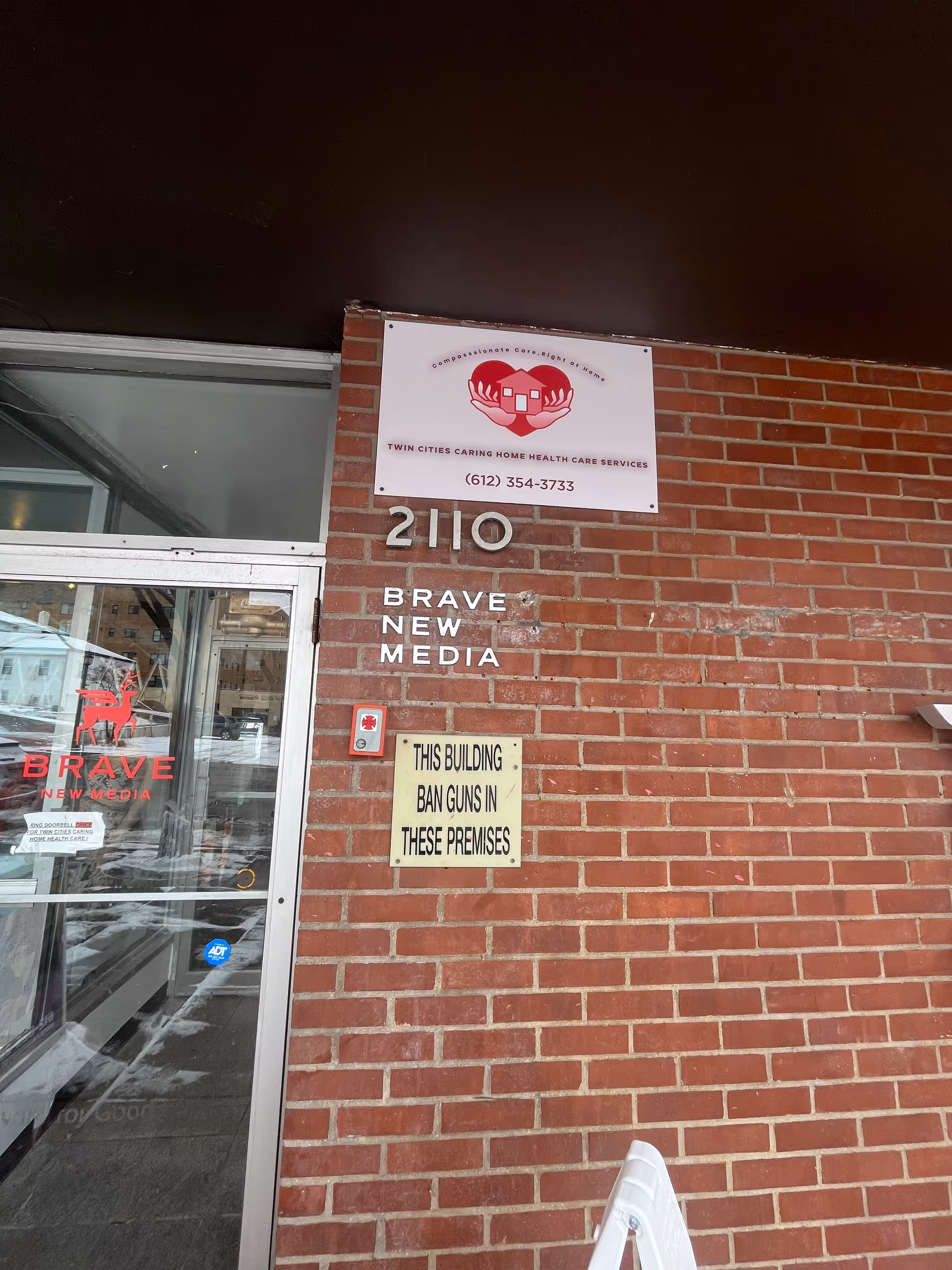 Brick building exterior with a front entrance and signage, including Twin Cities Caring Home Health Care.