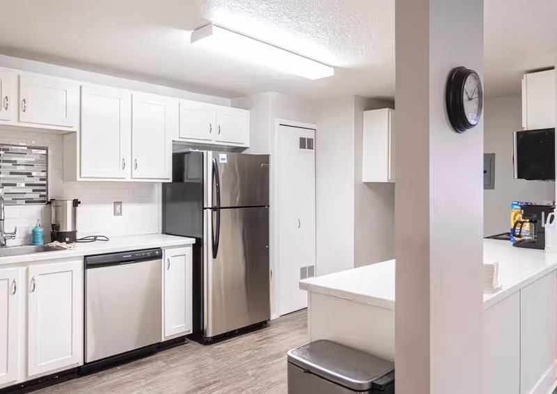 Bright kitchen with white cabinets, stainless steel appliances, and a central island.