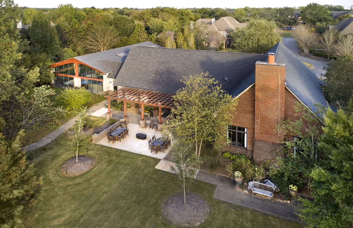 Aerial view of Oak Grove Inn campus with brick building, outdoor seating, and surrounding trees.