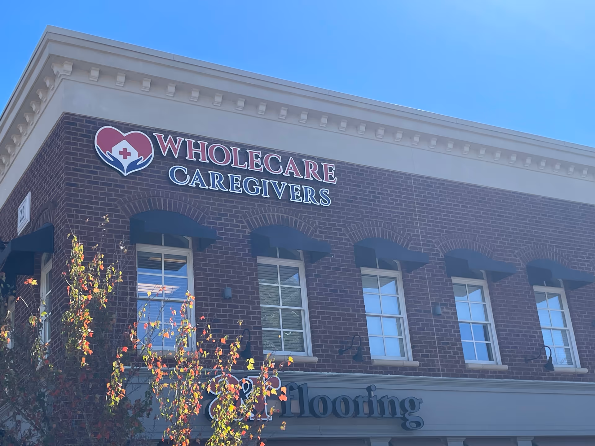 Brick exterior of a senior care facility with Wholecare Caregivers sign.