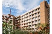 Exterior view of Lake Irma Retirement Home, a multi-story beige building with balconies and landscaping.