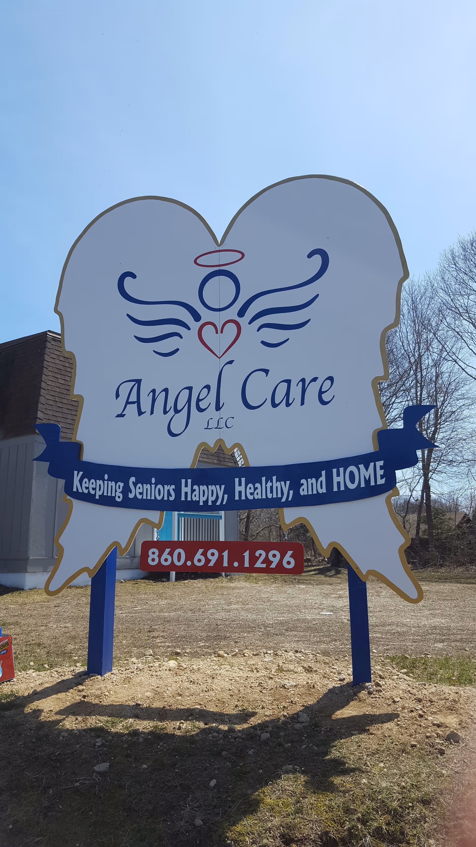 Outdoors, a large Angel Care LLC sign shaped like angel wings with phone number.