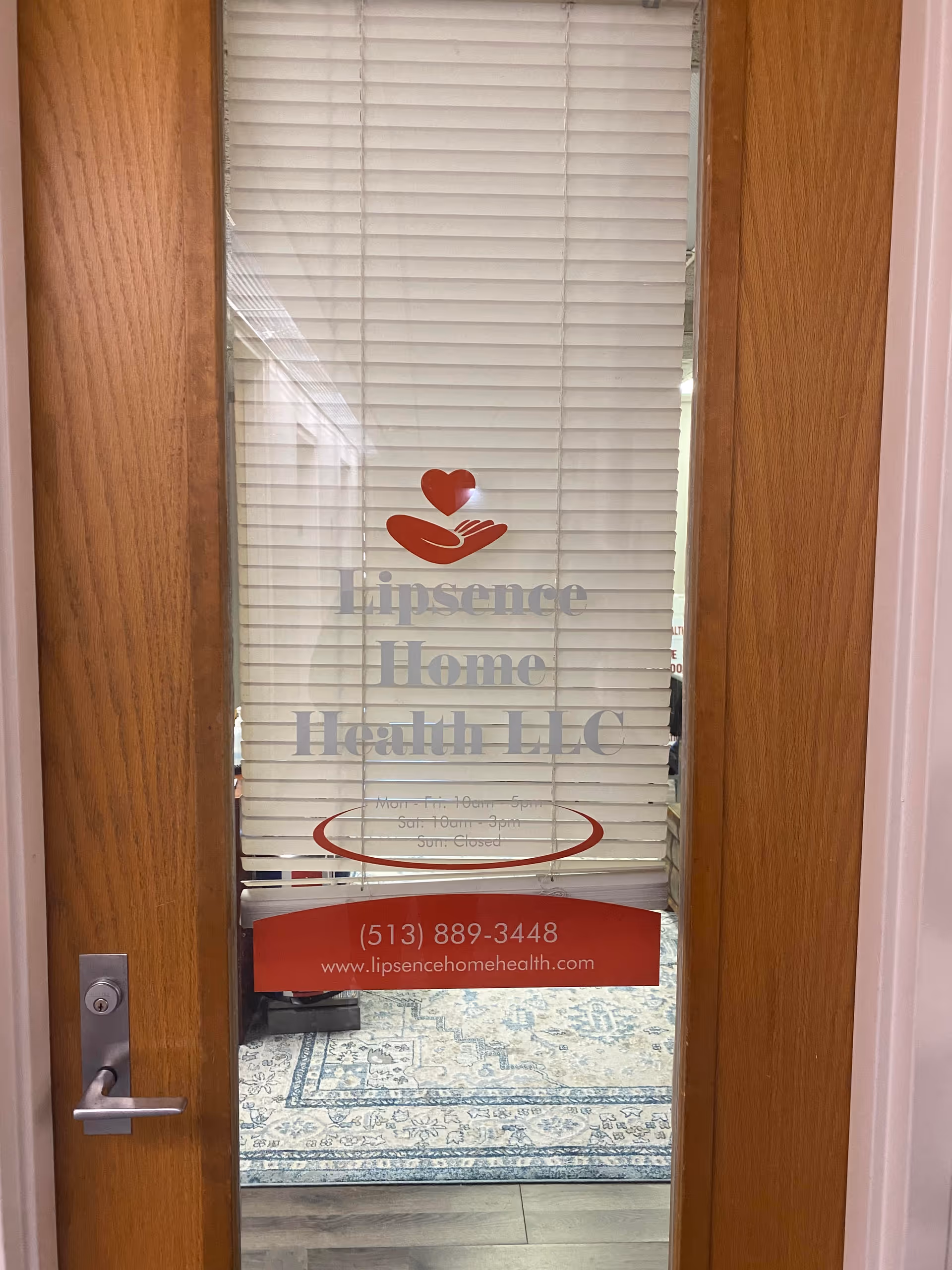 Wood door with blinds and Lipsence Home Health LLC sign on interior glass