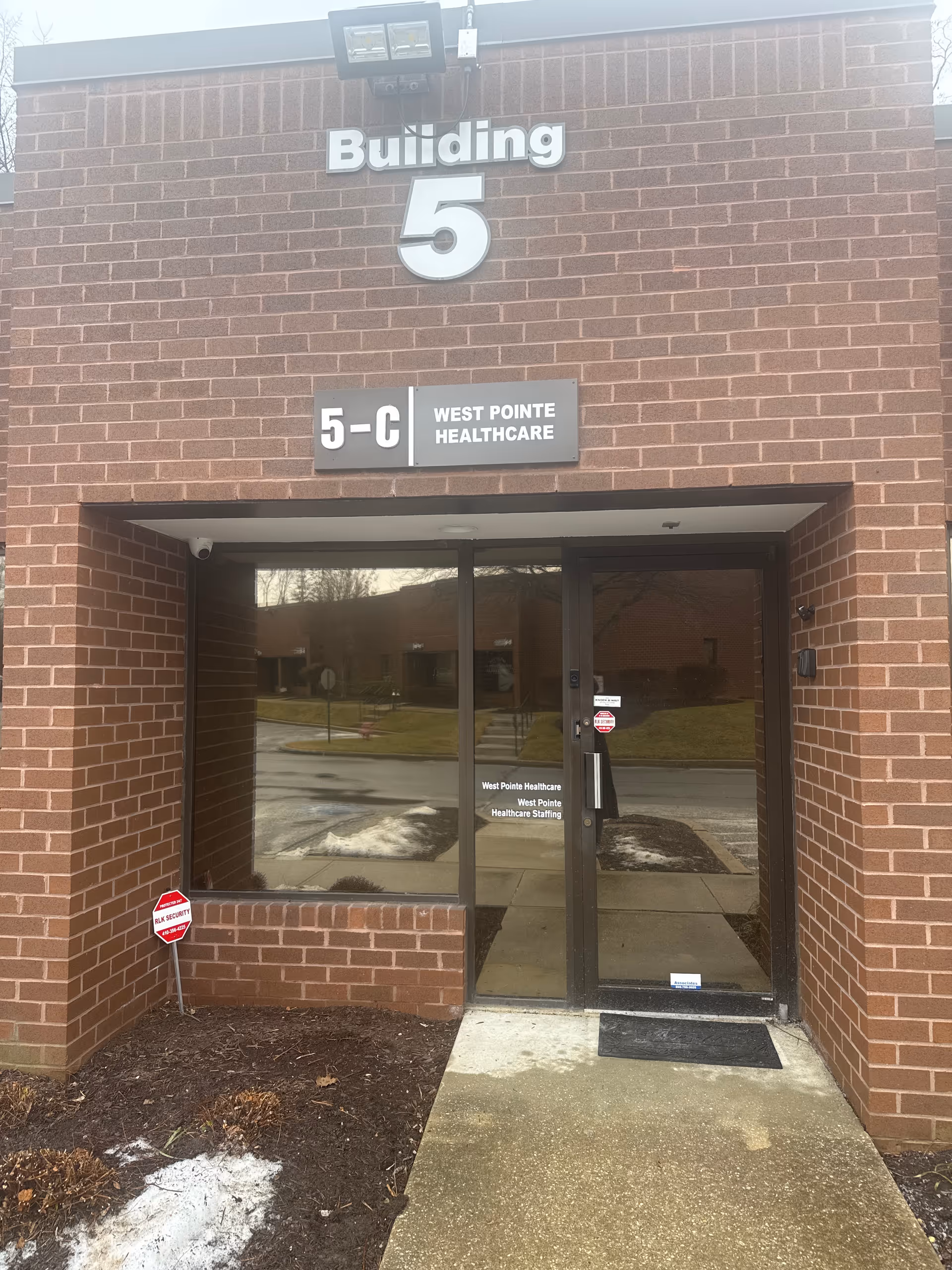 Brick exterior with Building 5 entrance and West Pointe Healthcare sign above doors.