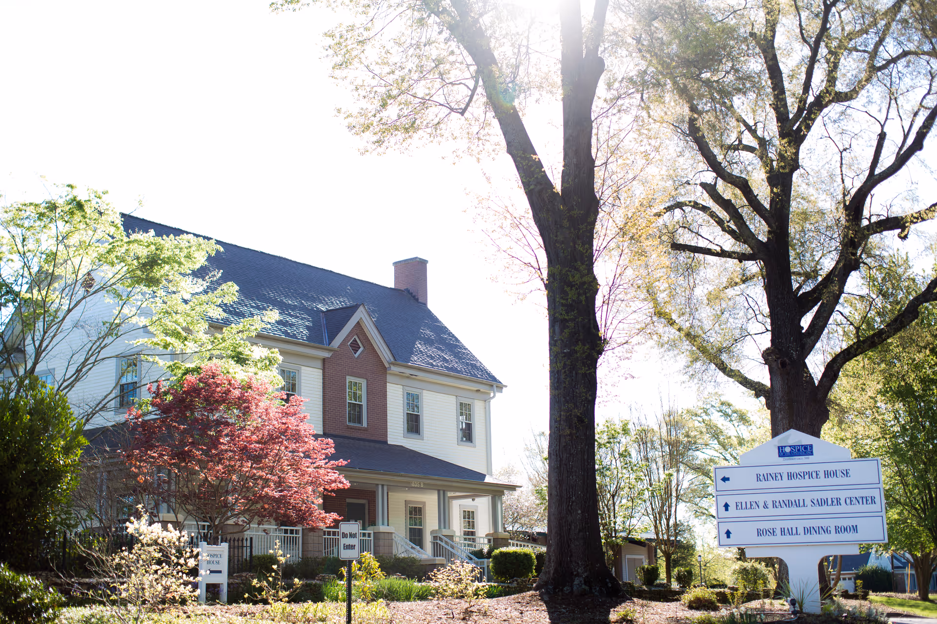 Hospice of the Upstate building exterior with a sign, trees, and daylight.