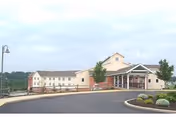 The Meadow View Nursing Center exterior shows a beige building with landscaped entrance and circular driveway.