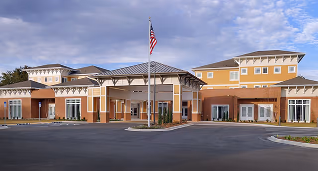 Exterior view of Summer Vista Assisted Living building with a covered entrance and flagpole.