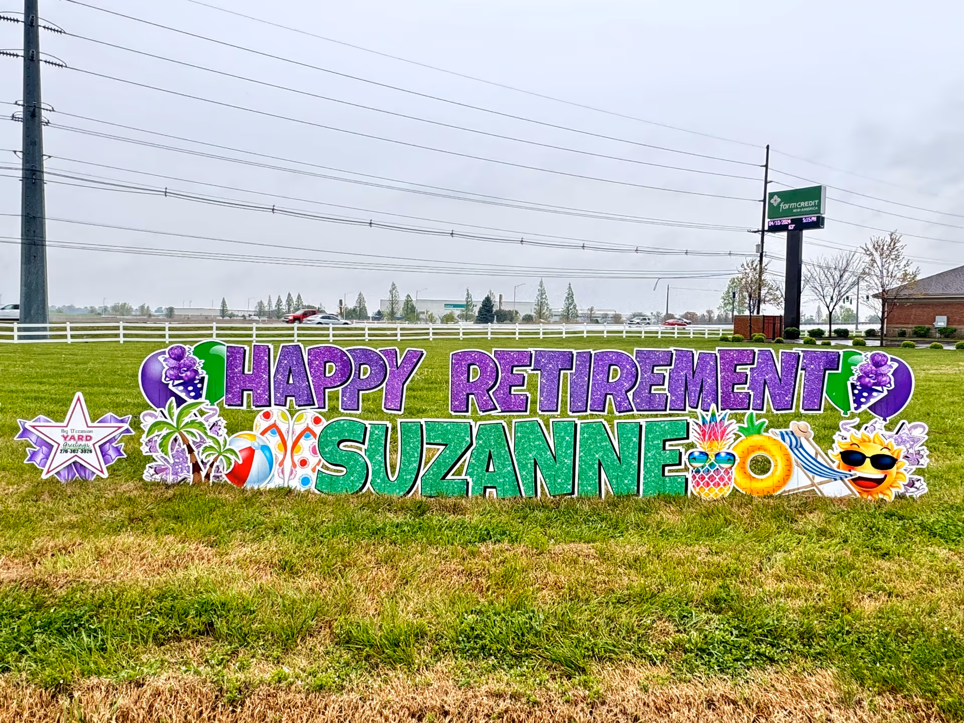 Colorful retirement sign reading 'Happy Retirement Suzanne' on a grassy lot.