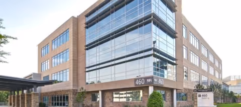 Modern brick-and-glass medical building with large windows and exterior address sign.