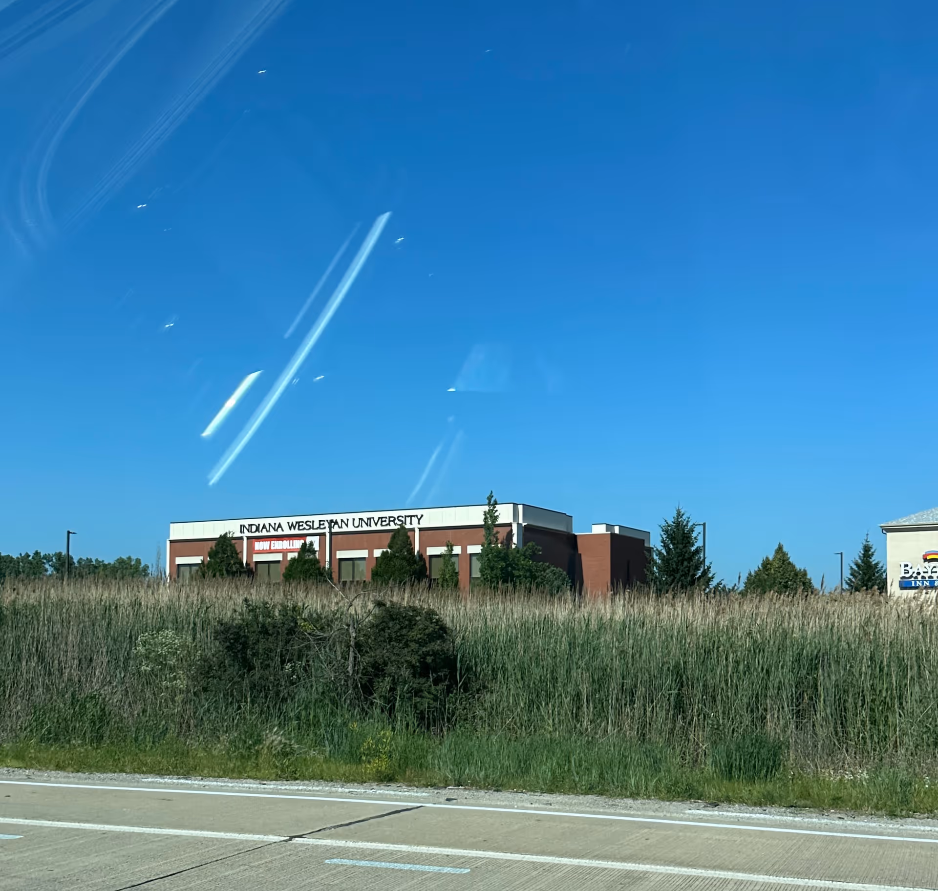Front exterior of Indiana Wesleyan University building with tall grass in foreground.