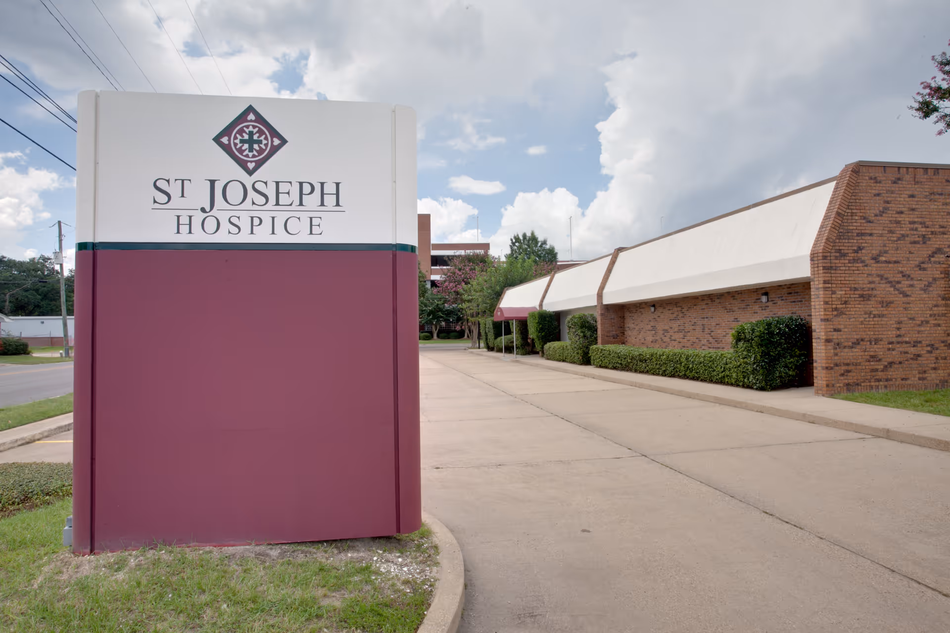 Front view of St. Joseph Hospice sign beside a brick exterior building