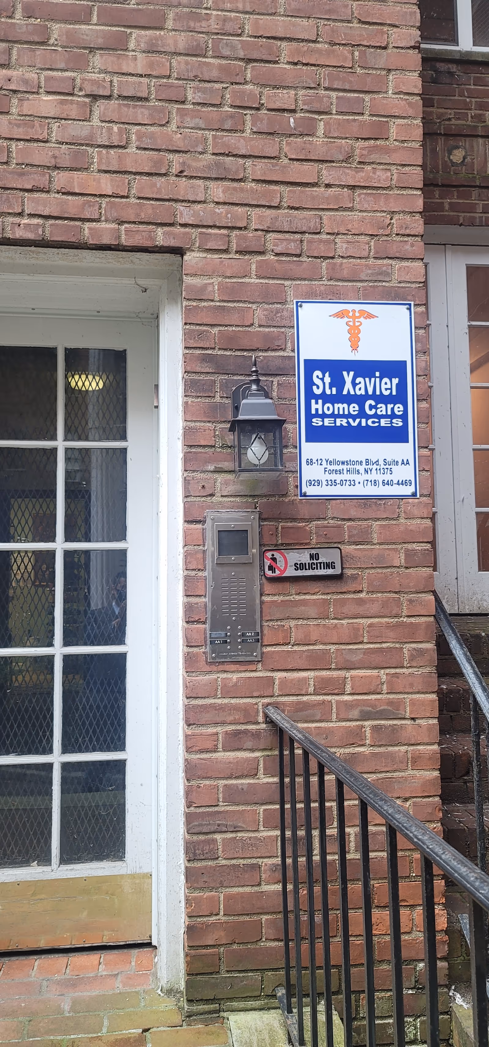 Brick exterior with St. Xavier Home Care Services sign beside glass door.