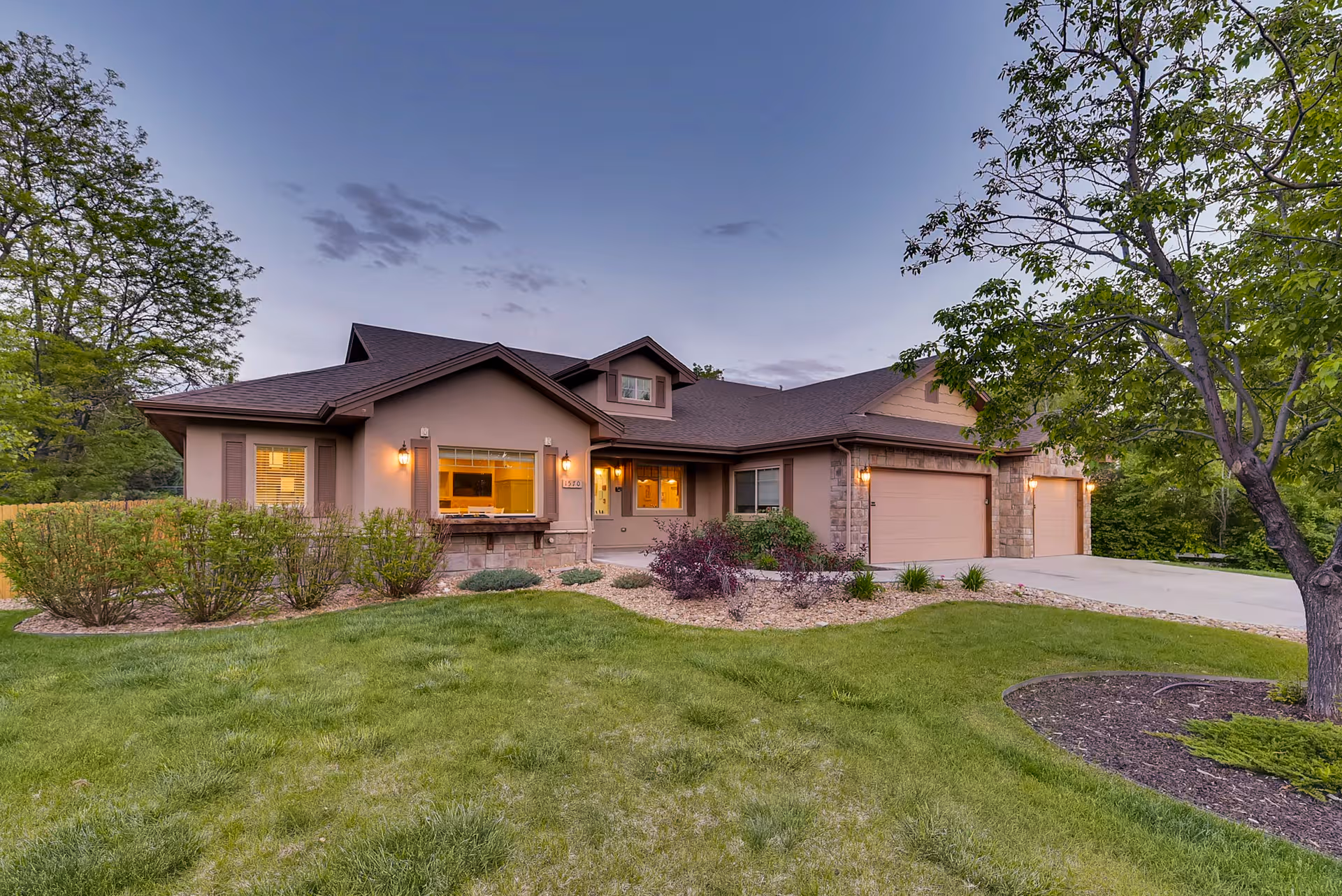 Exterior of Rocky Mountain Assisted Living, a single-story home with landscaping and an attached three-car garage.