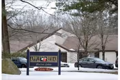 Exterior view of Apple Rehab Shelton Lakes facility with sign and snow-covered parking lot.