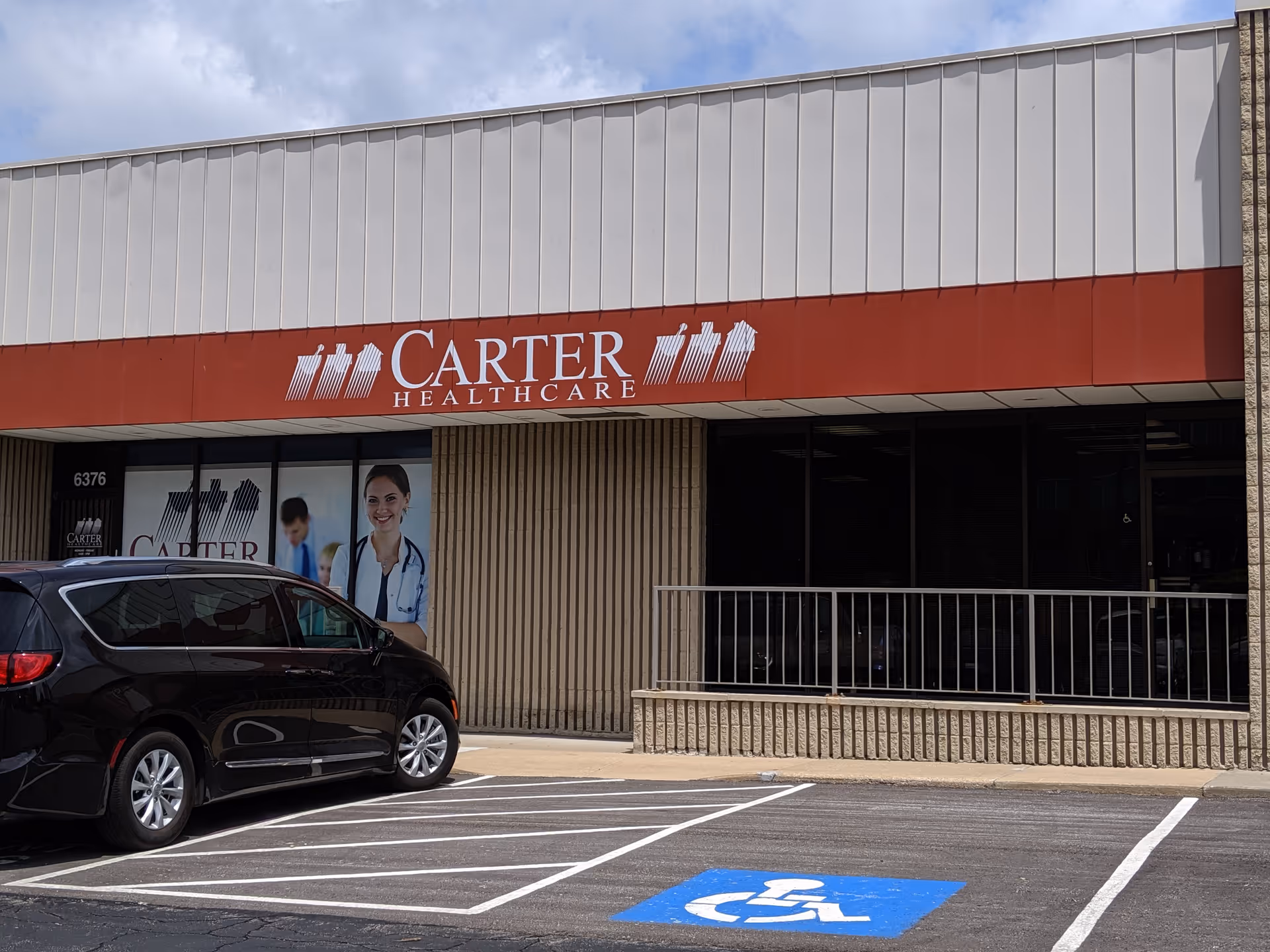Carter Healthcare storefront with red sign, large windows, parking lot, wheelchair accessible symbol.