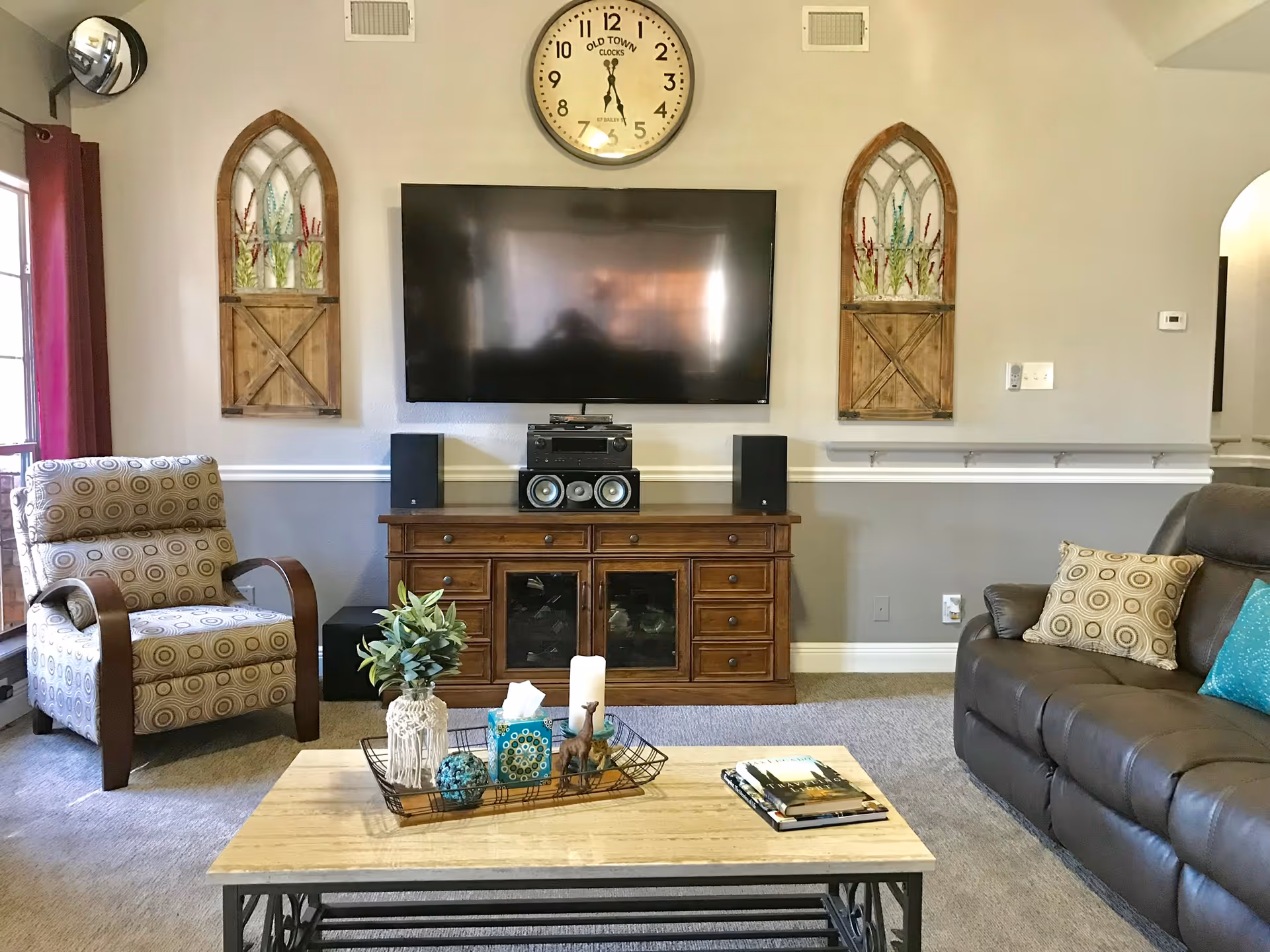 Cozy living room featuring a wall-mounted TV, sofa, armchair, coffee table, and decorative niches.