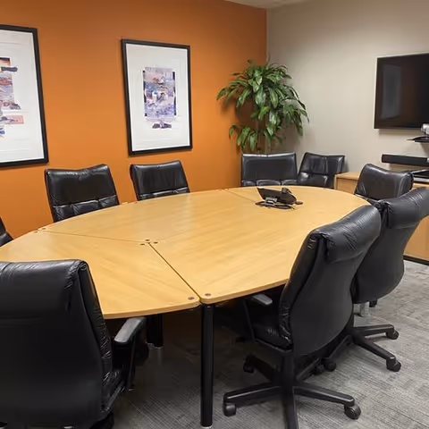 Empty conference room in a senior living facility with oval table and chairs.