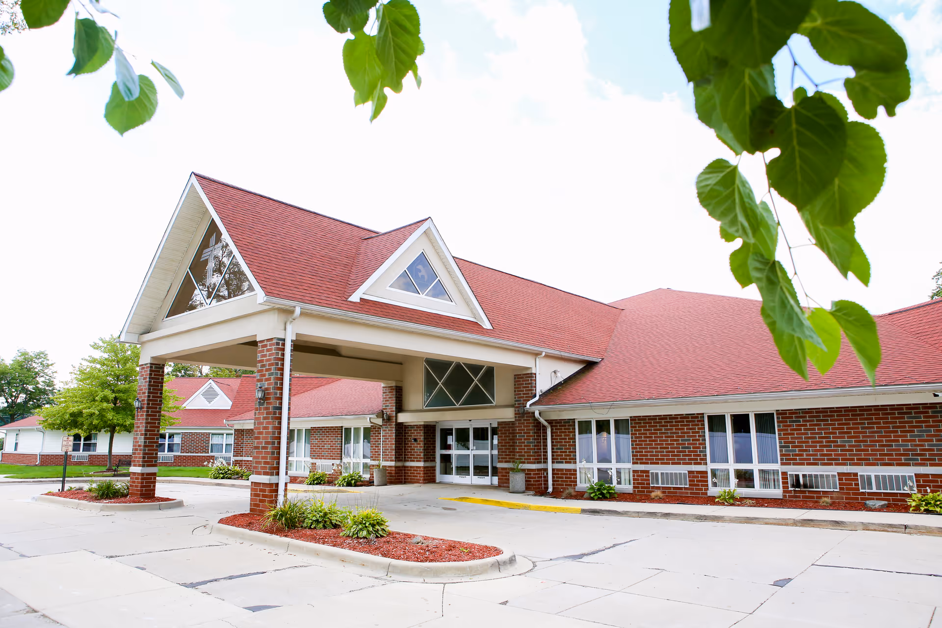 Front view of Fountain Bleu Health and Rehab Center exterior with red roof and brick facade.