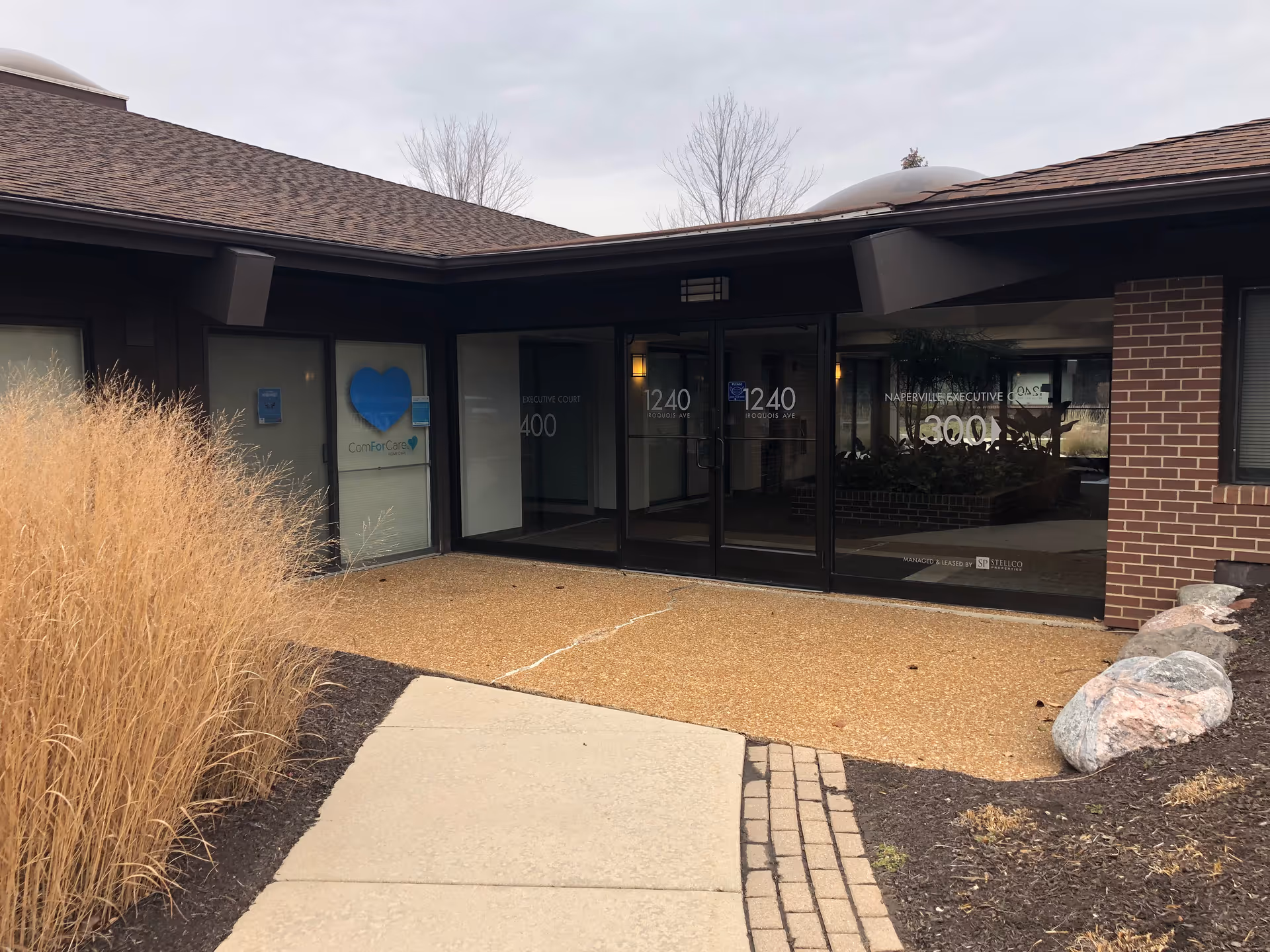 Exterior entrance to a ComForCare home care facility with glass doors and brick walls.