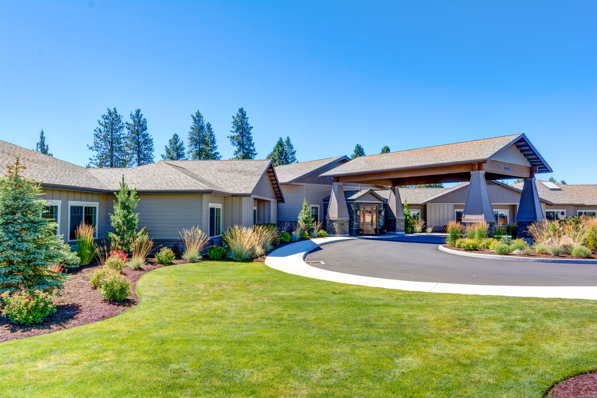 Exterior view of Mt. Bachelor Memory Care with a covered entrance and landscaped grounds.