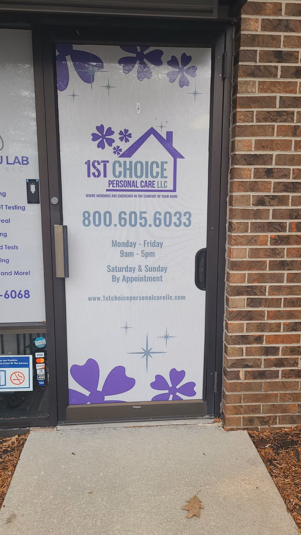 Front door of 1st Choice Personal Care with purple floral graphics and brick facade.
