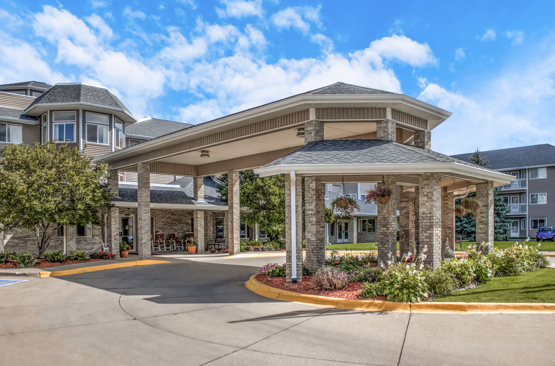 Exterior view of Mallard Point Senior Living with porte-cochere entrance and landscaped grounds.