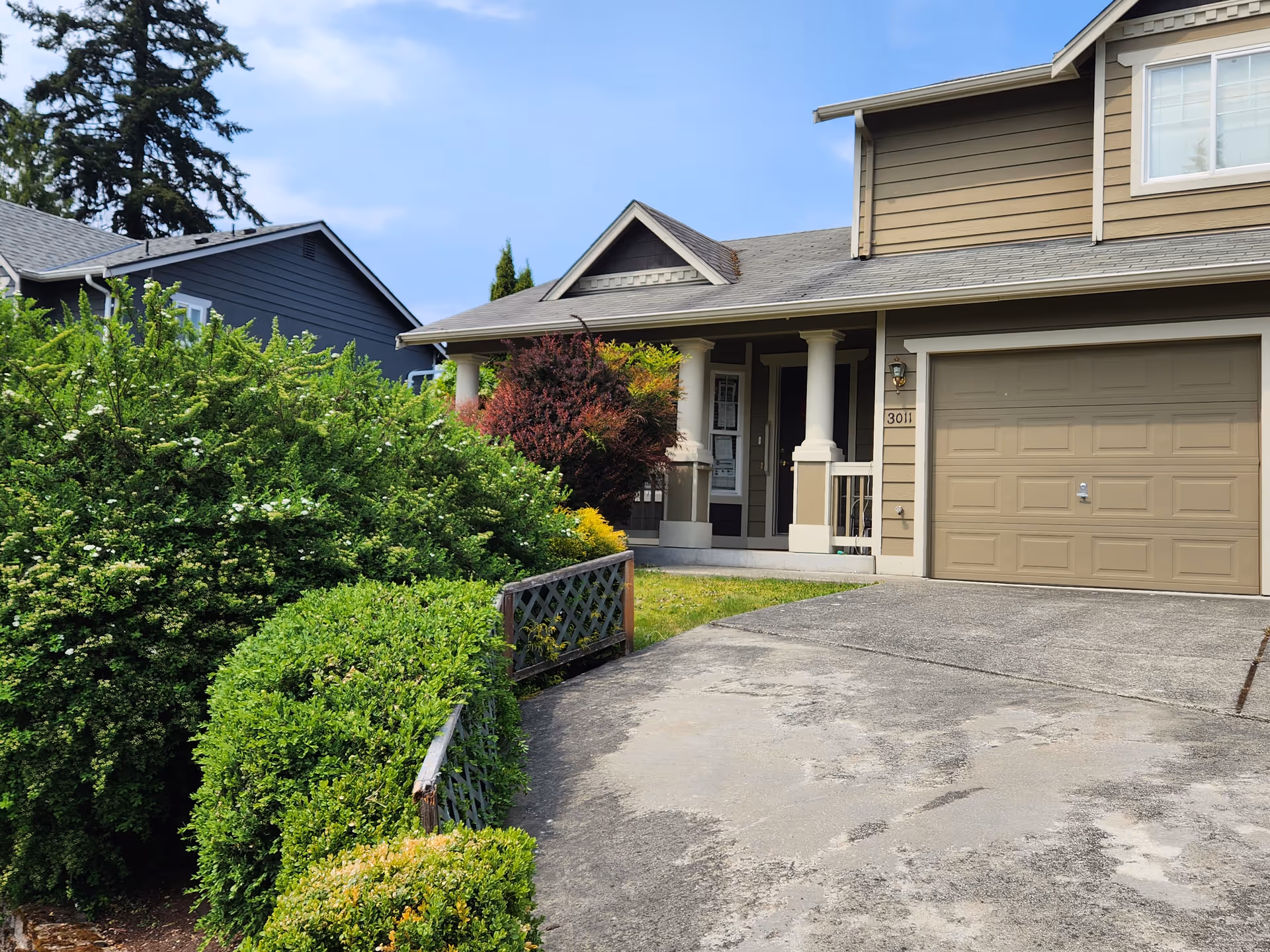 Front exterior of Mukilteo Green House residence with driveway and garage.