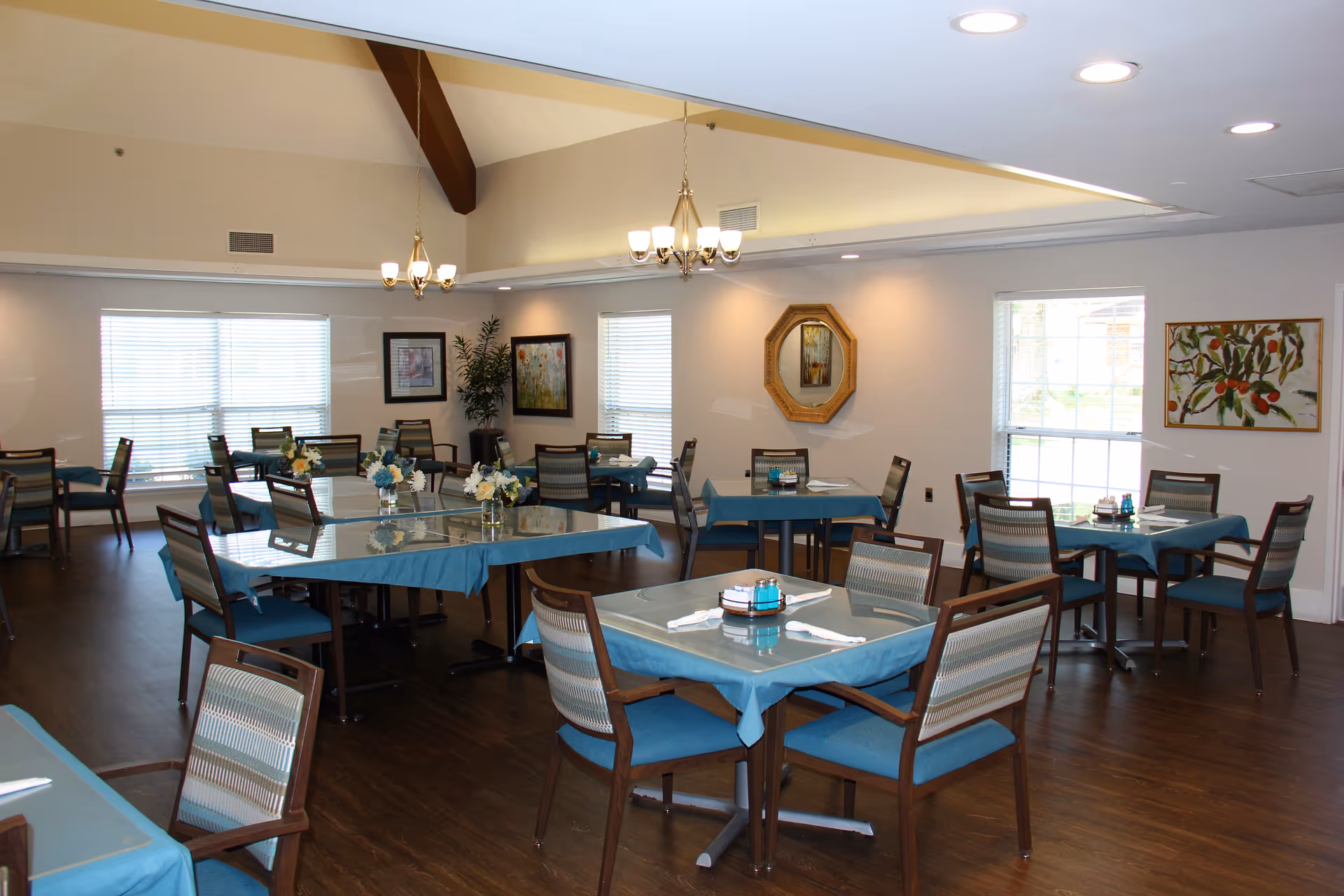 Bright dining room with blue tablecloths and neatly set tables in Parkway Heights facility.