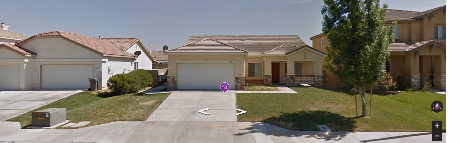 Single-story suburban house with an attached two-car garage, driveway, and front lawn.