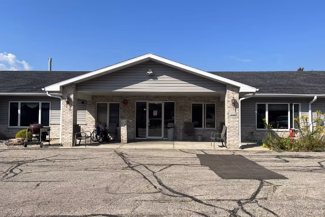 Front view of VitaCare Living of Cross Plains building with entrance and outdoor seating.