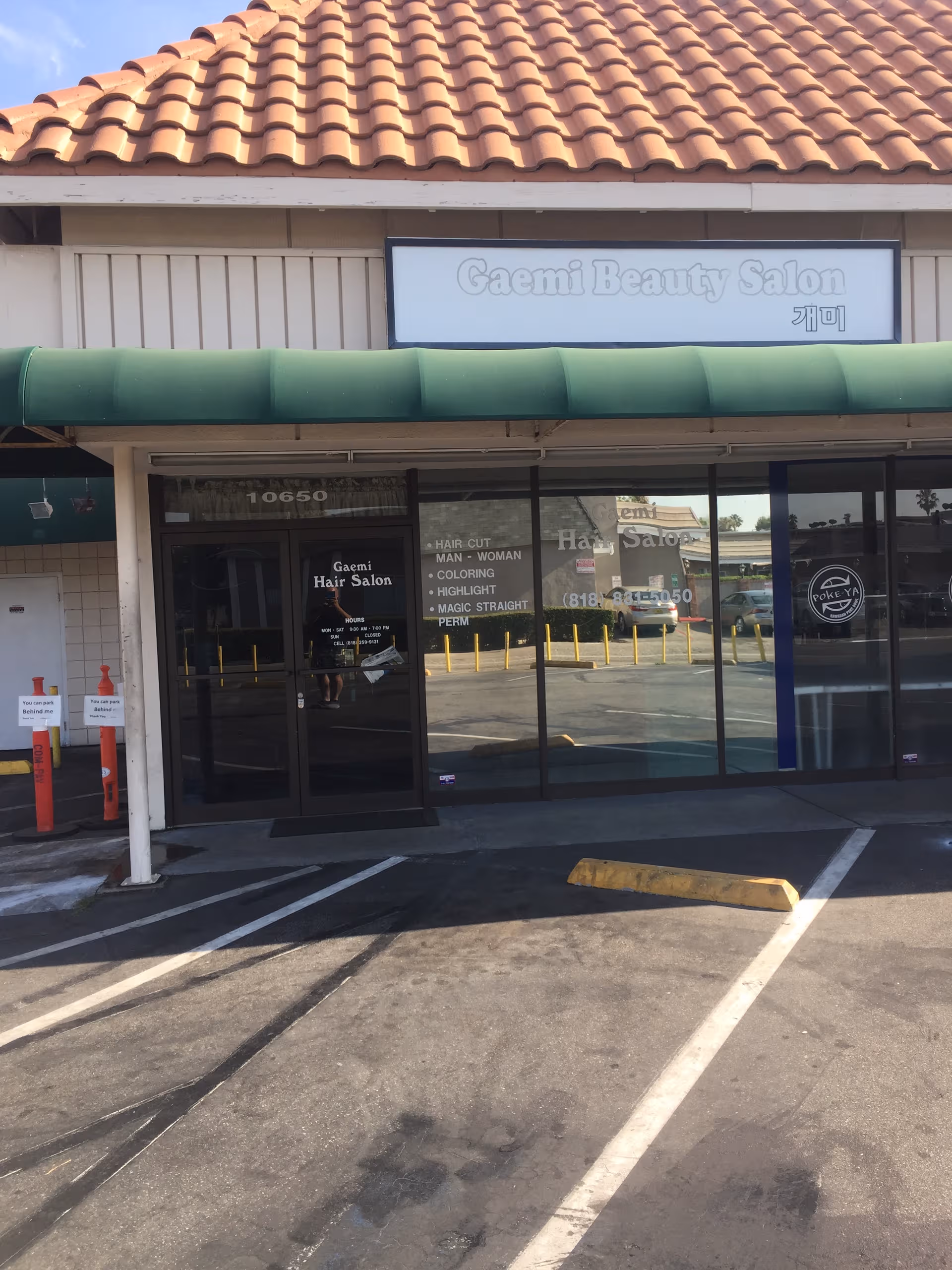 Facade of a strip mall with Gaemi Beauty Salon storefront and a green awning.