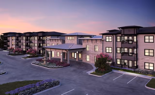 Exterior view of Solea Cinco Ranch senior living facility with central entrance and landscaping.