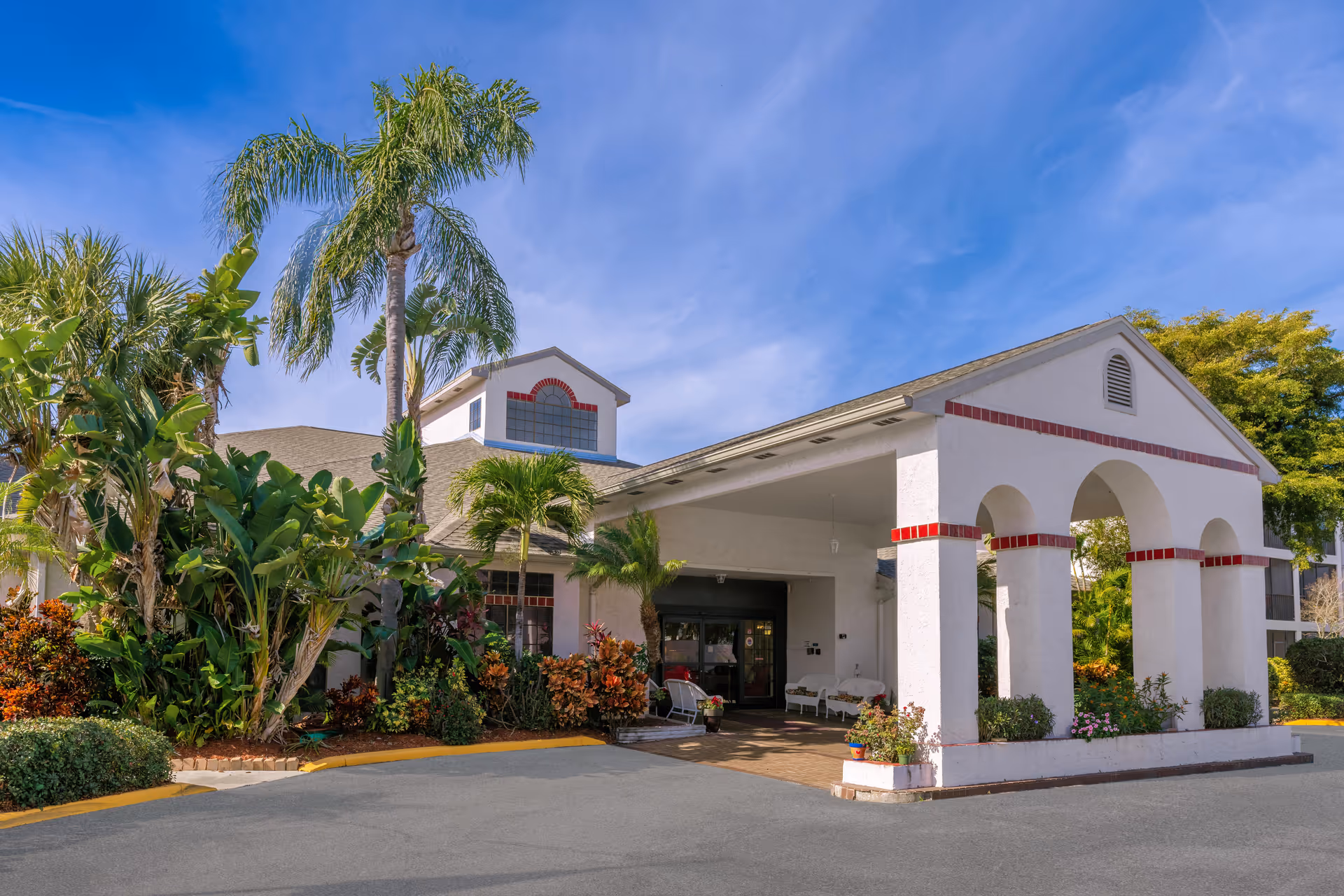 Exterior view of Regency Residence Sky Active Living with arches and tropical landscaping
