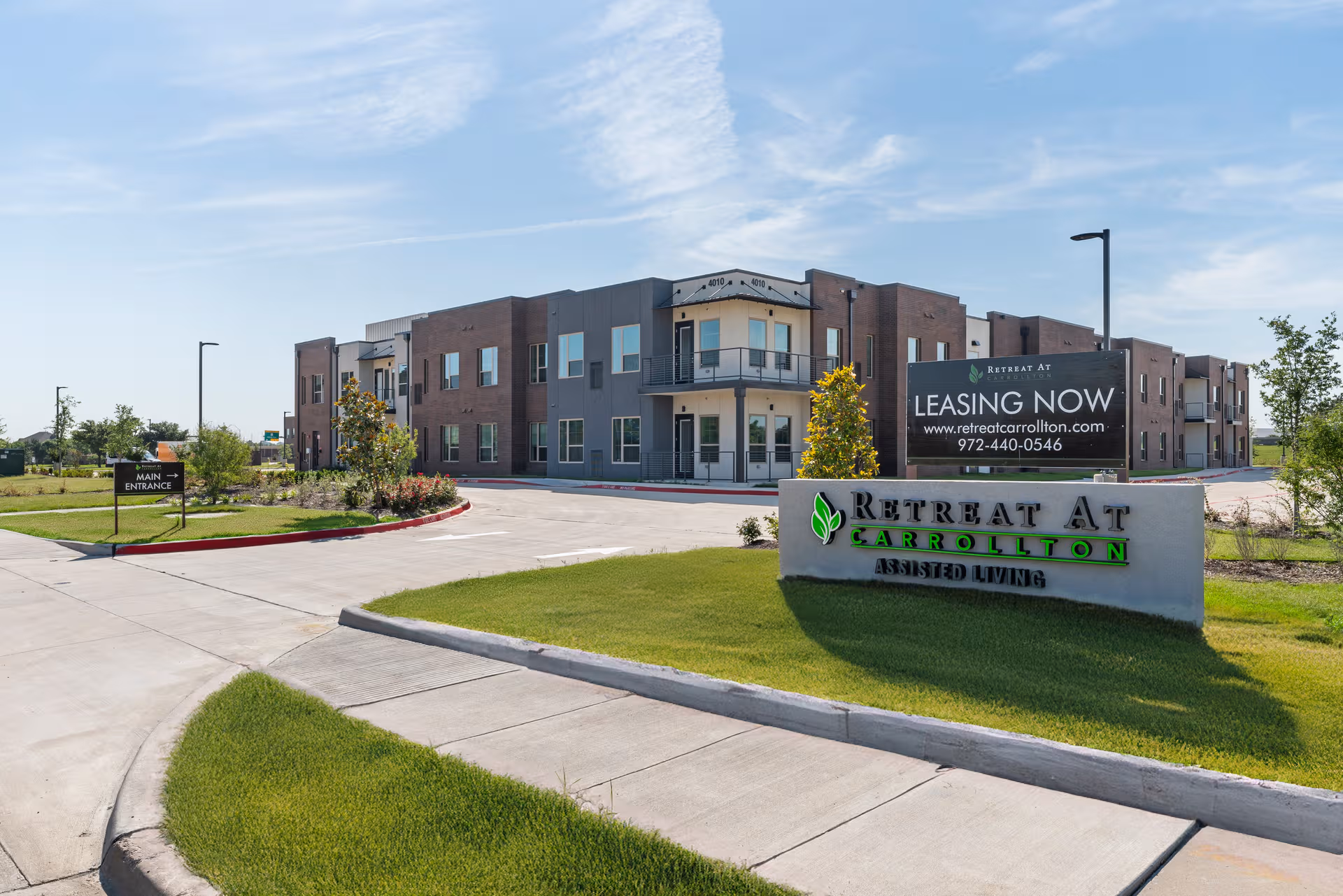 Exterior view of a modern senior living building with a Retreat At Carrollton sign