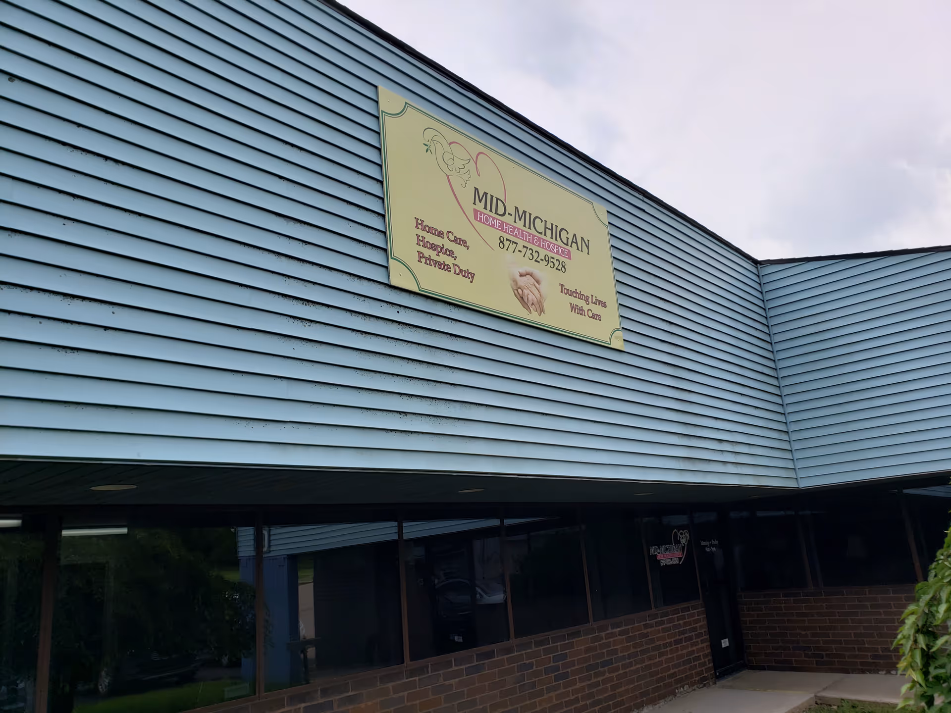 Front view of a blue building with a Mid-Michigan Home Health & Hospice sign.
