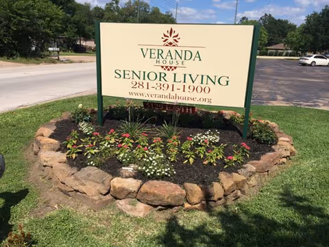 Veranda House Senior Living sign surrounded by a flower bed on a sunny lawn