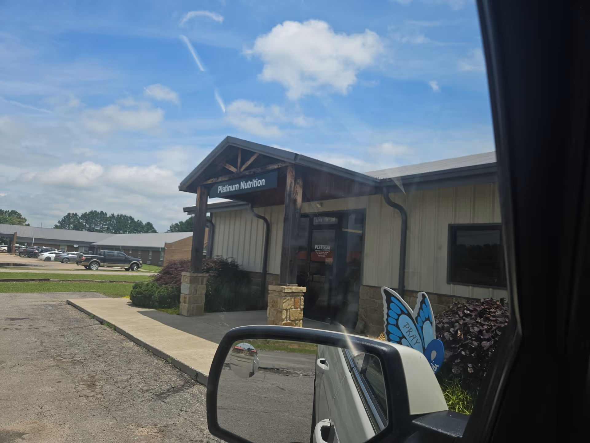 Exterior view of a Platinum Health Care entrance with wooden portico and butterfly sign.