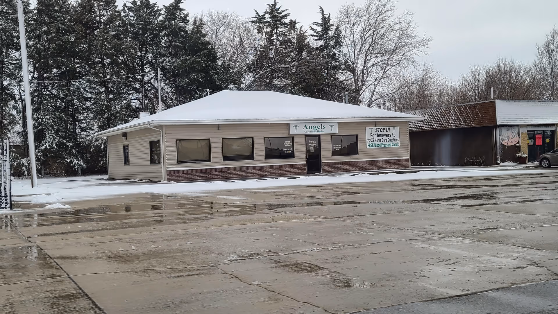 Snowy street view of Angels Care Home Health building with a front entrance sign.