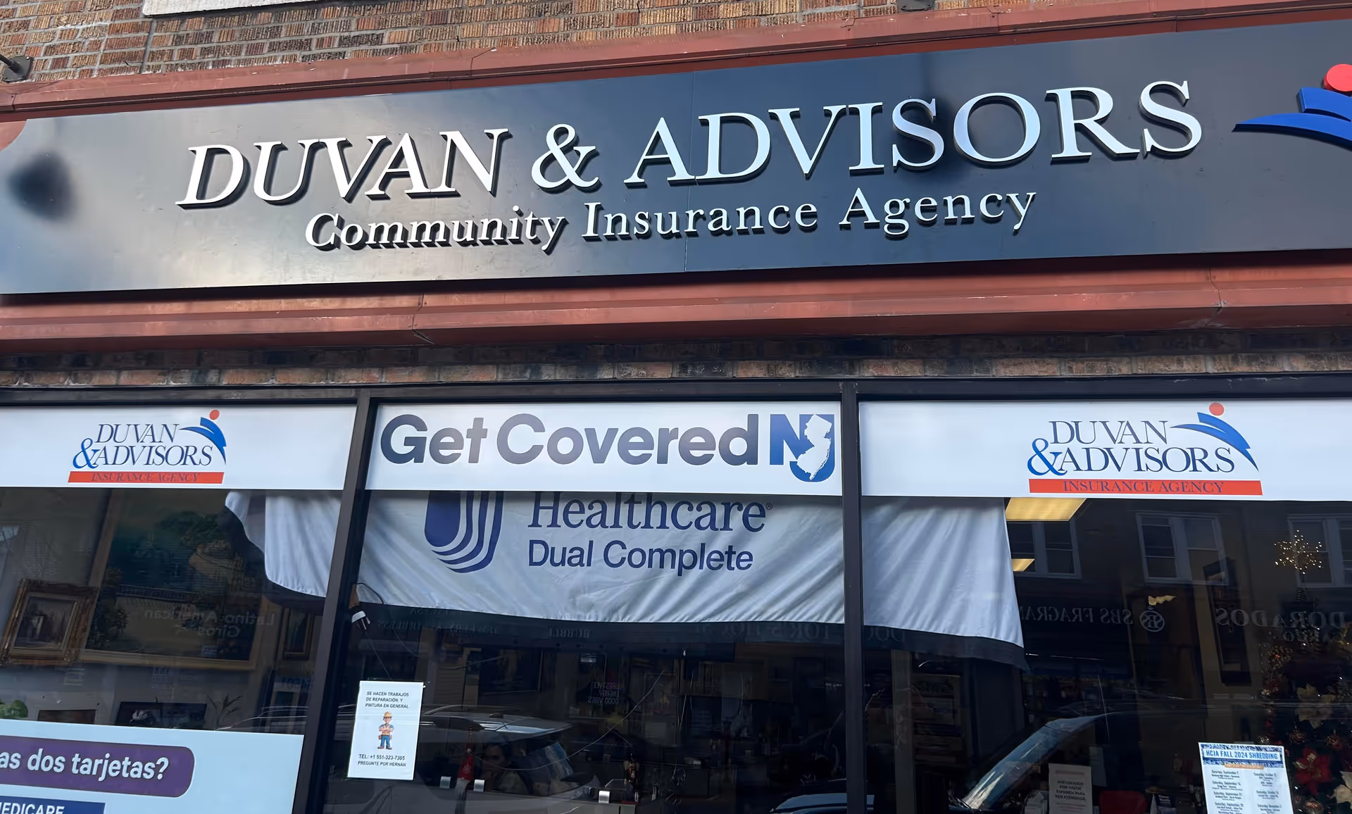 Storefront signage for Duvan and Advisors Insurance Agency with banners and windows.