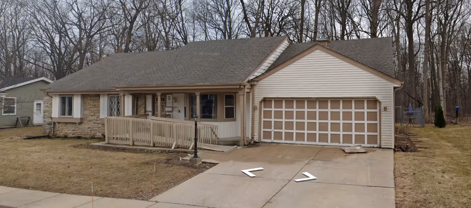 Single-story retirement home with a ramp, front entrance, and a two-car garage.