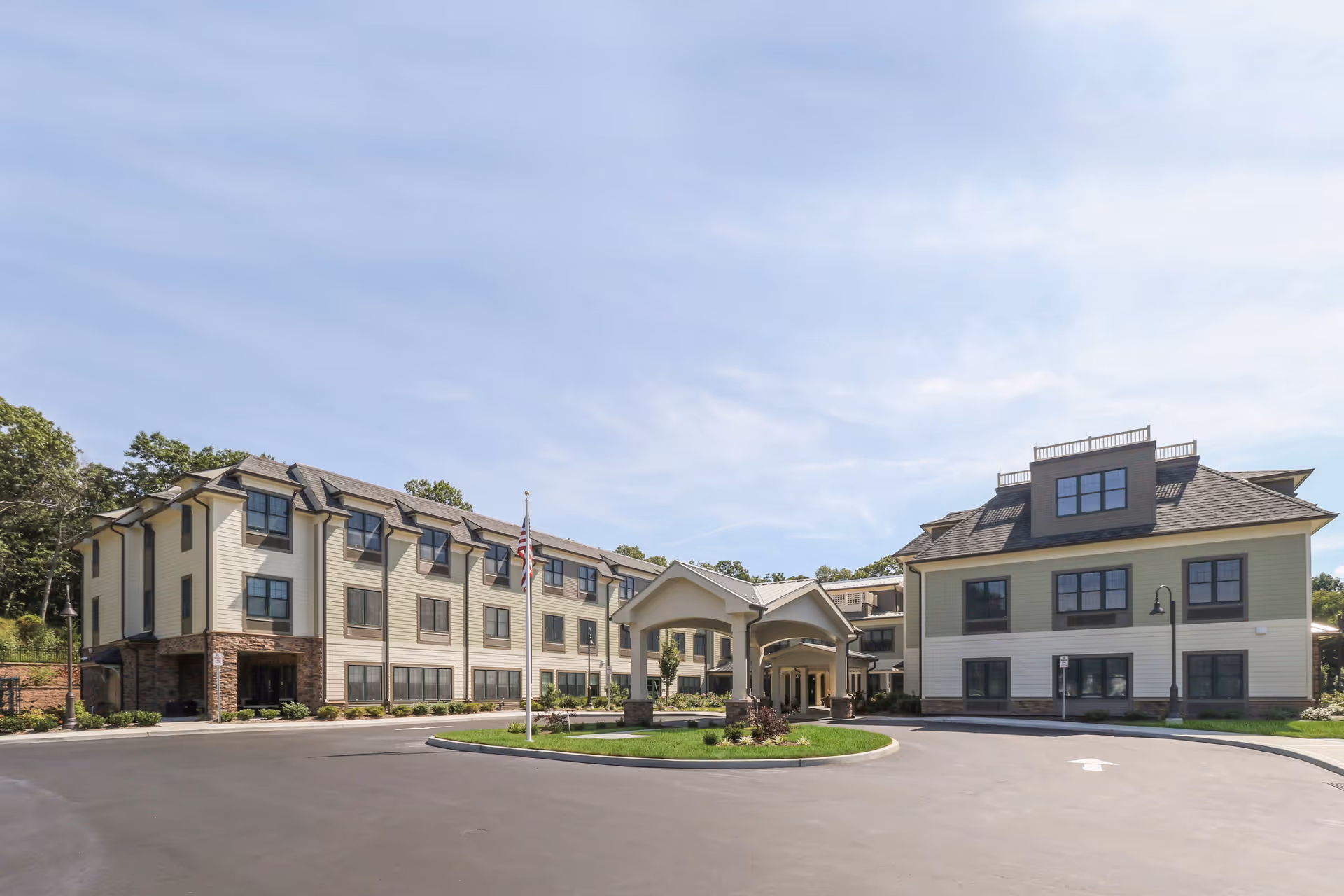 A multi-story assisted living campus with a curved driveway and front entrance.