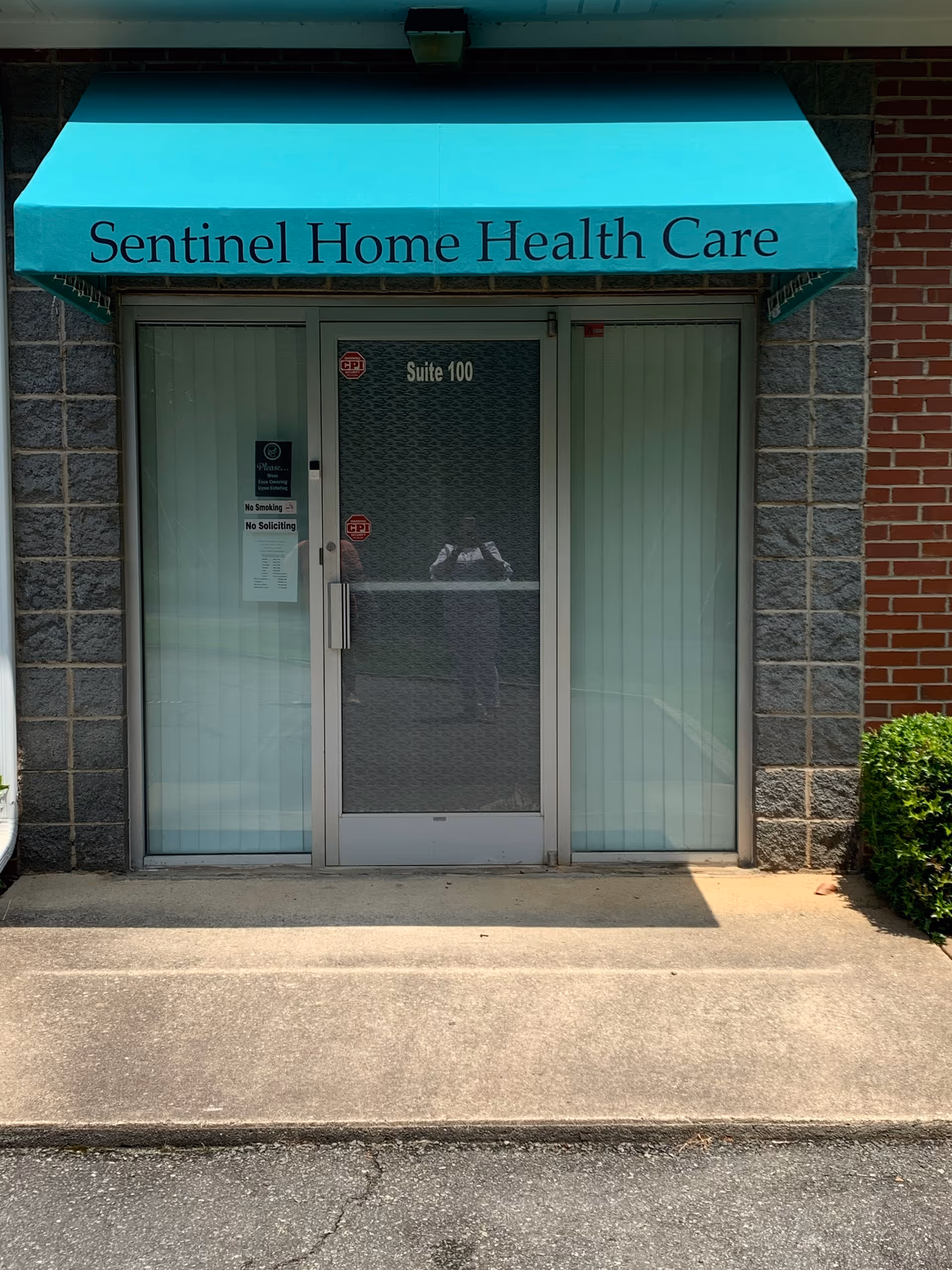Front entrance of Sentinel Home Health Care under a teal awning.