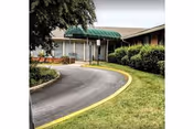 Exterior view of a nursing home entrance with curved driveway and green awning.