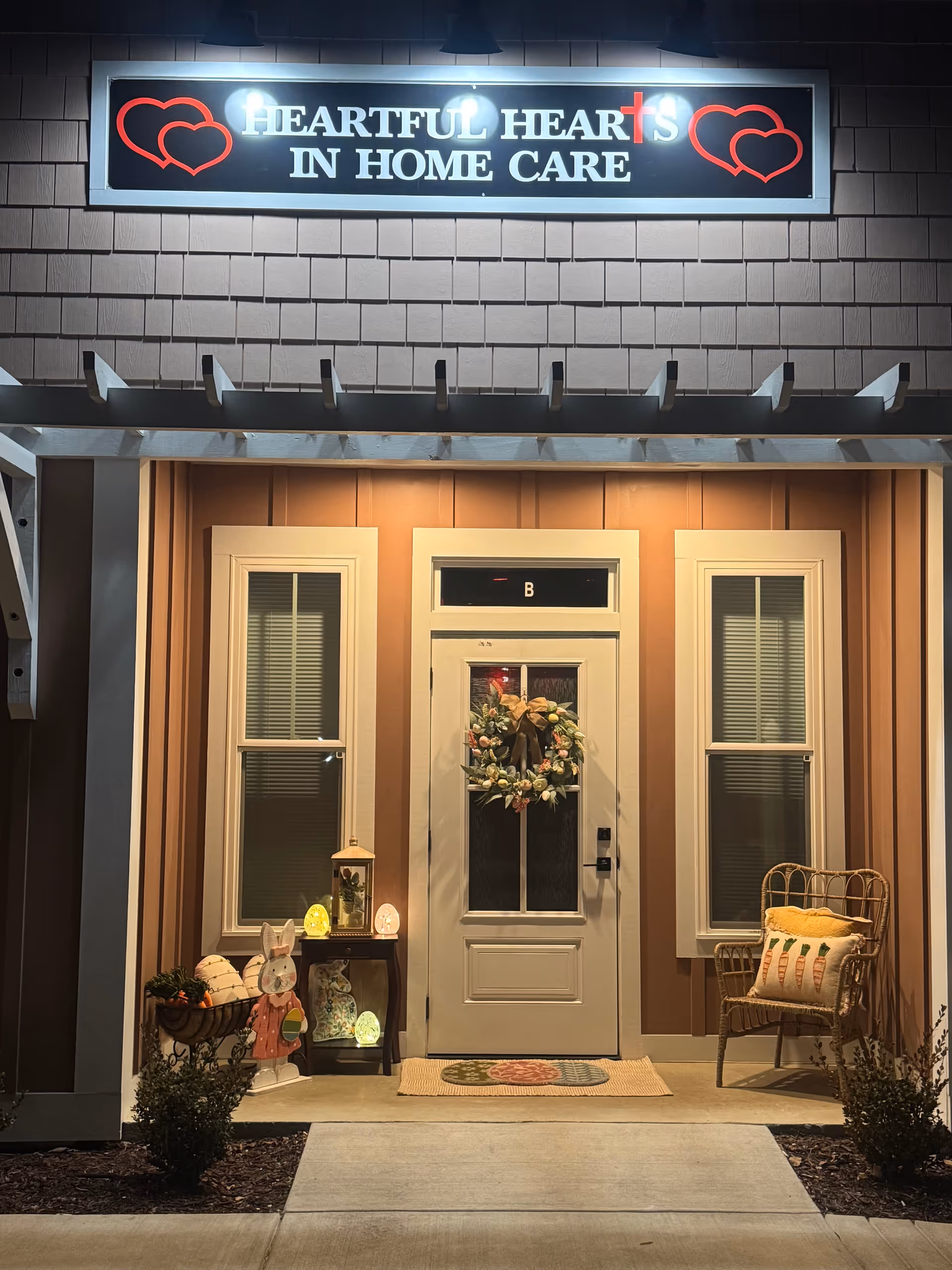 Exterior view of Heartful Hearts In Home Care entrance with wreath and chair on porch.